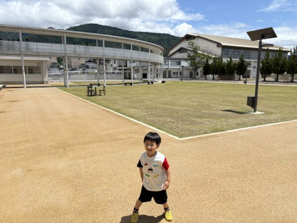リンクむらやまの青空の下で手を広げる4歳の息子の写真