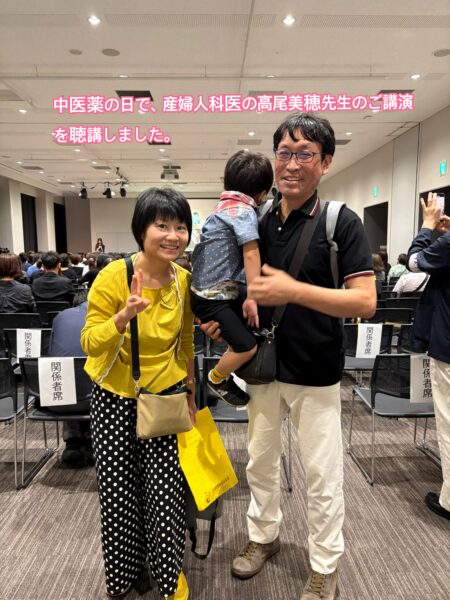 中医薬の日特別セミナー会場に参加した土屋薬剤師夫婦と4歳の息子。息子は恥ずかしがって後ろ向き
