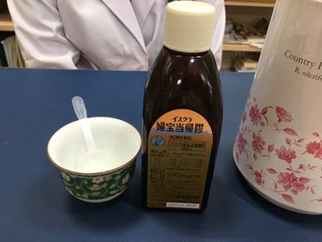 婦宝当帰膠のボトルと湯のみを並べたシーン。毎日の冷え対策・美容養生に役立つ漢方薬。