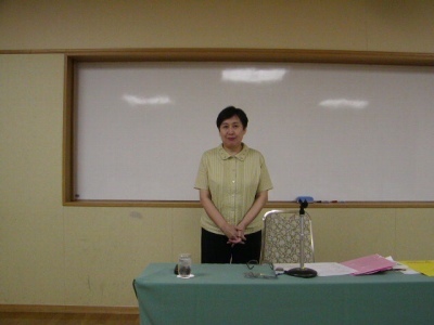 中医師・包海燕先生が講演で『男女の更年期と神経症』について解説している様子。穏やかな表情でマイクを手に語りかける姿が印象的。南東北中医薬研究会の会場で撮影された一枚で、更年期を中医学の視点から丁寧に説明している。