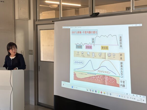 妊活セミナーで張立也先生が基礎体温表を指しながら、高温期の見方や排卵日の判断、着床しやすい体づくりについて中医学の視点で説明している講義風景。妊活と漢方、体外受精・着床不全（RIF）をサポートする基礎体温の読み解き方を解説する様子。