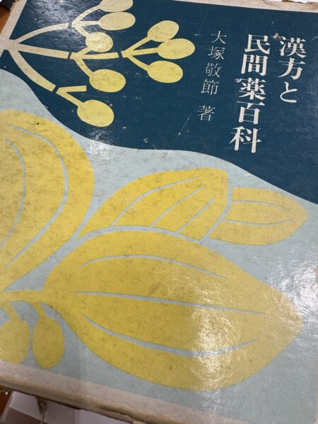 大塚敬節『漢方と民間薬百科』の本が机に置かれた写真。皮膚病漢方の原点に立ち返り学び直すために開いた参考書。