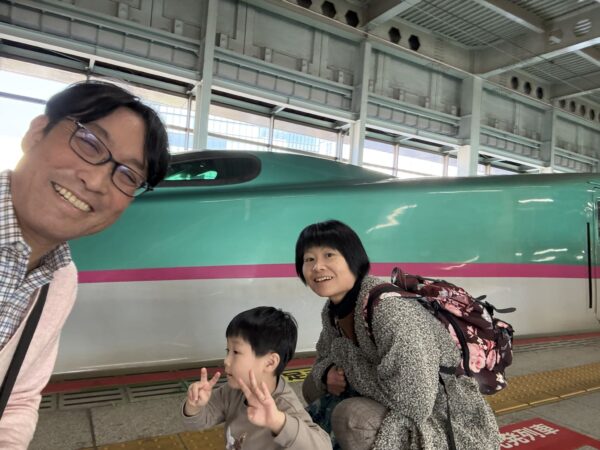 仙台駅新幹線ホームではやぶさを背景に撮影した家族3人の写真