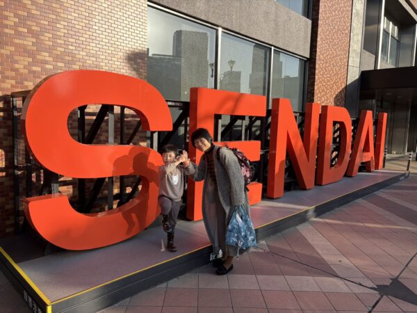 仙台駅の「SENDAI」サイン前で撮影した家族3人の記念写真