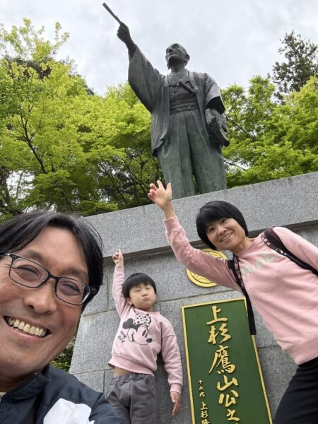 「なせばなる」で知られる上杉鷹山公の銅像前で笑顔を見せる土屋幸太郎さんご家族。山形での暮らしや家族との時間を大切にしながら、妊活相談や漢方相談に取り組んでいる様子。