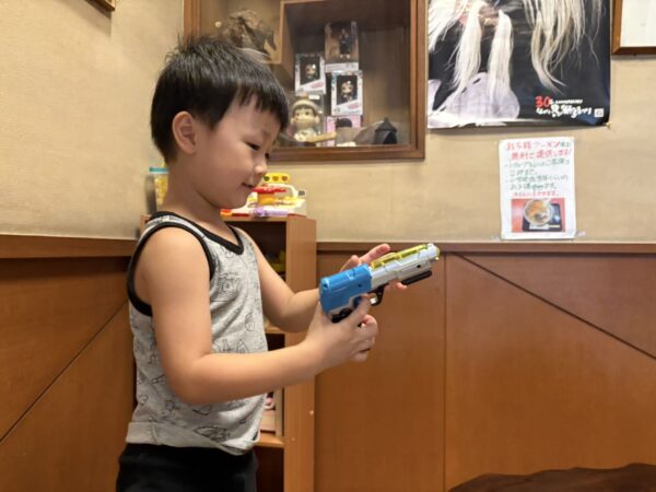 小上がりで銃のおもちゃを手に取る息子です。