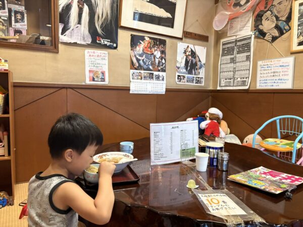 小上がりでラーメンを食べる息子です。