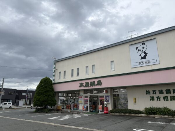 梅雨空の土屋薬局外観。湿度が高い山形県東根市の様子