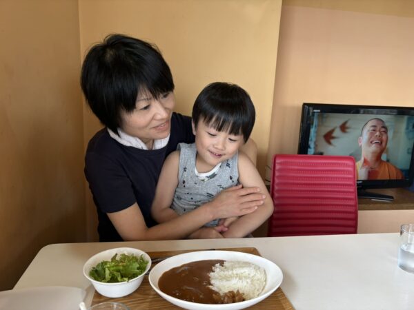 東根市の未来食堂でカレーを前に笑顔を見せる妻と5歳の息子
