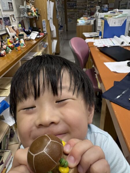 講演会当日の午前10時、土屋薬局で講演会の準備をする土屋幸太郎を待ちながら「待てなーい」と笑顔を見せる5歳の息子