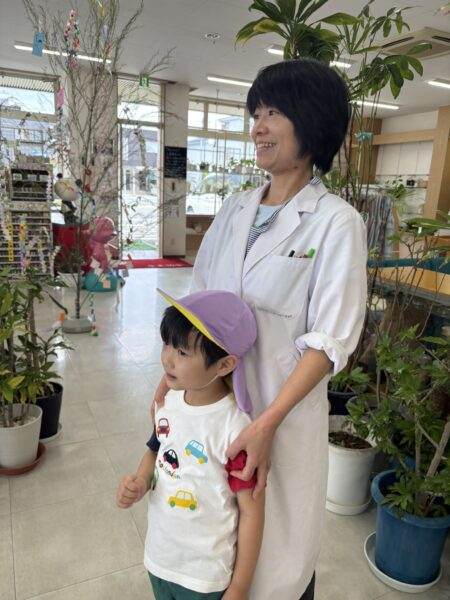 土屋薬局で神町幼稚園の七夕飾りを眺める5歳の息子と白衣姿の妻