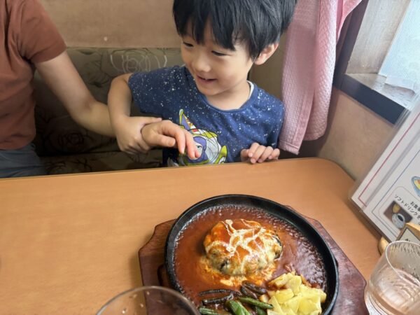 東根市の洋食店「パパアンドママ」で運ばれてきたチーズハンバーグを見て思わずにっこり笑顔になる5歳の息子。家族で過ごす楽しいランチタイム。