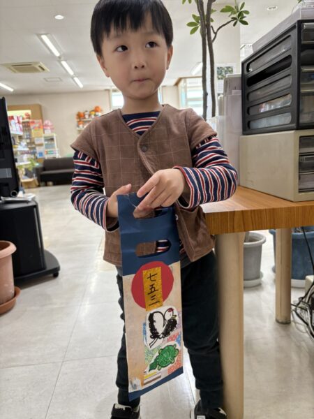 千歳飴の袋をもって微笑む息子