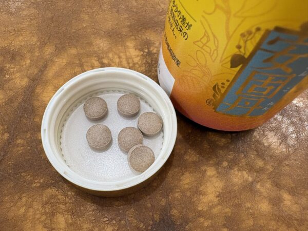 星火安固丹の粒と黄色いラベルのボトル