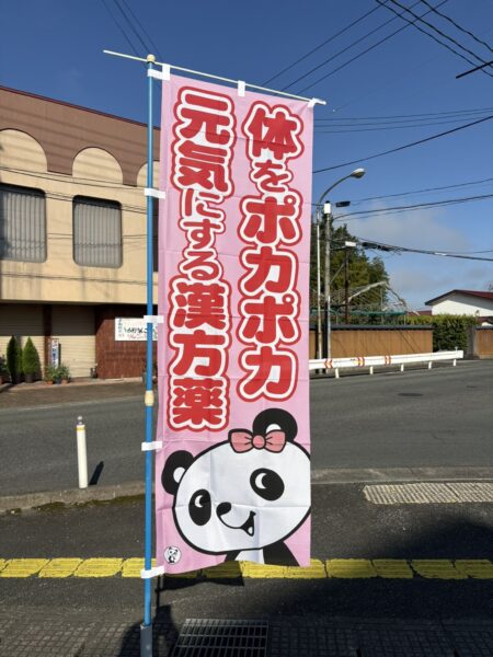 土屋薬局の駐車場に設置した、パンダが描かれた「体をポカポカ元気にする漢方薬」ののぼり